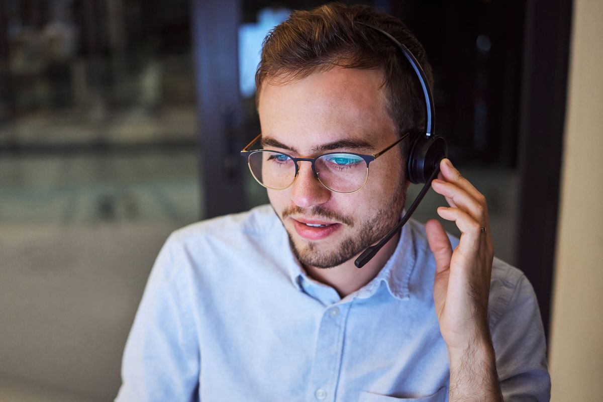 IT-Support-Mitarbeiter mit Headset im Kundengespräch
