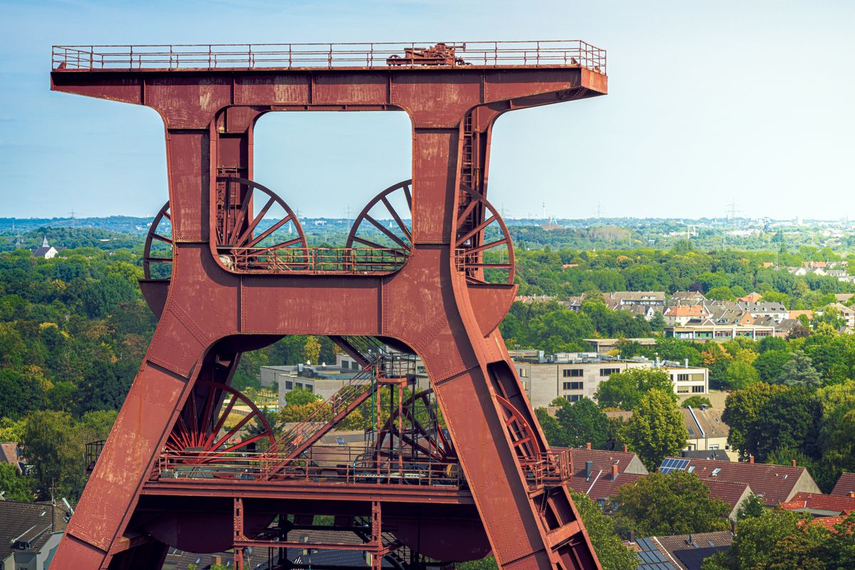 Doppelbock-Fördergerüst der Zeche Zollverein vor der grünen Landschaft des Ruhrgebiets